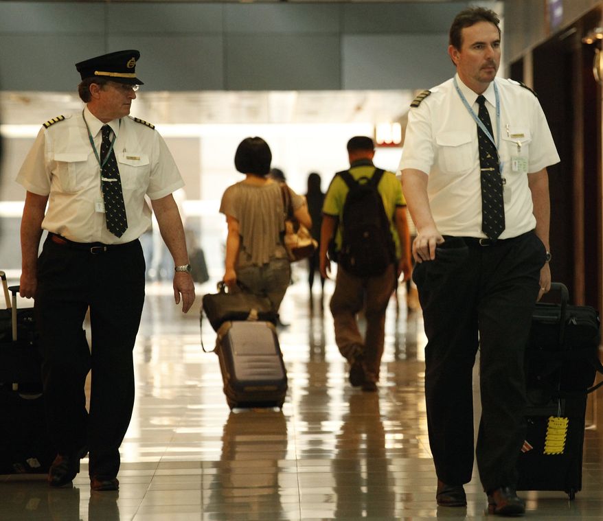 In this Nov. 30, 2011, photo, two pilots from Cathay Pacific walk in the Hong Kong International Airport in Hong Kong. The U.S. airline industry will need to hire 1,900 to 4,500 new pilots annually over the next 10 years due to an expected surge in retirements of pilots reaching age 65 and increased demand for air travel, the Government Accountability Office said in the report obtained late Thursday, Feb. 27, 2014. (AP Photo/Vincent Yu, File)