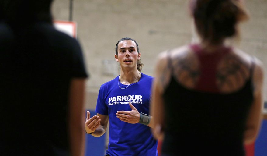 In this Wednesday, Jan. 29, 2014 photo, Blake Evitt, an instructor with Parkour Generations Americas, talks with his students during a Parkour training class in Brookline, Mass. (AP Photo/Charles Krupa)