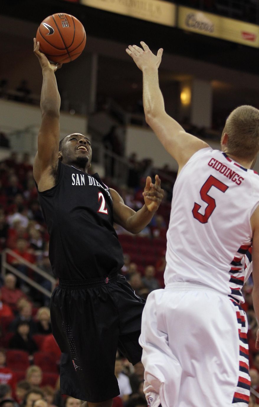 San Diego State's Xavier Thames puts up a shot over Fresno State's Tanner Giddings in the first half of an NCAA college basketball game in Fresno, Calif., Saturday, March 1, 2014. (AP Photo/Gary Kazanjian)