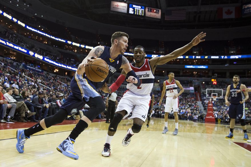 Memphis Grizzlies forward Mike Miller, left, drives past Washington Wizards guard John Wall during the first half of an NBA basketball game on Monday, March 3, 2014, in Washington. (AP Photo/ Evan Vucci)