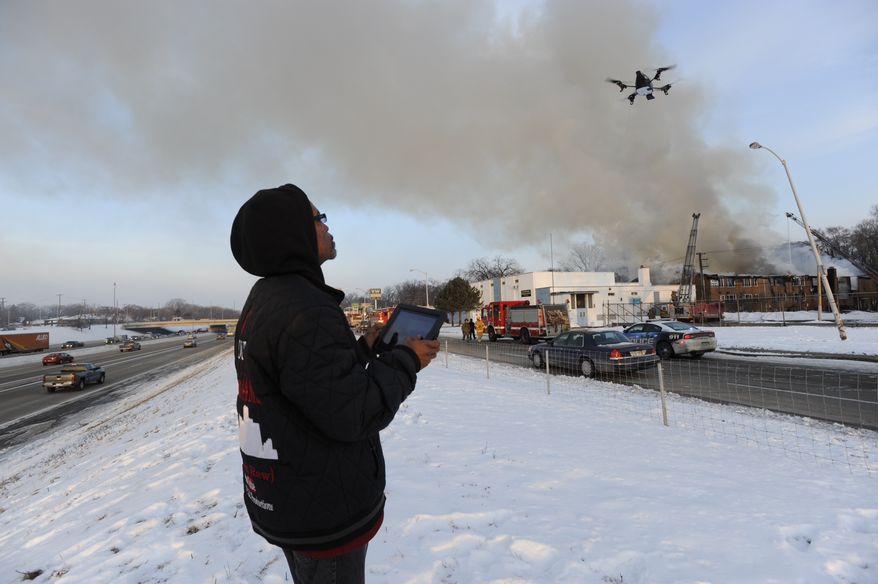 Sanford Miles pilots a drone to shoot video of a large fire at an apartment building in Detroit, Wednesday, March 5, 2014. There were no immediate reports of any deaths caused by the fire at the Jason Manor Apartments, which broke out at about 6 a.m. Four people were taken to hospitals for treatment, Detroit Fire Commissioner Jonathan Jackson said. (AP Photo/Detroit News, David Coates) DETROIT FREE PRESS OUT; HUFFINGTON POST OUT; MAGS OUT; MANDATORY CREDIT