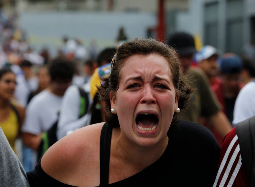 A student of Venezuela's Central University (UCV), shouts slogans against Venezuela's President Nicolas Maduro during a protest in Caracas, Venezuela, Wednesday, March 12, 2014. According to local authorities, several deaths have been reported Wednesday, and a number of others, including National Guardsmen, have been wounded after being shot by unknown assailants in separate incidents in the central Venezuelan city of Valencia. (AP Photo/Fernando Llano)