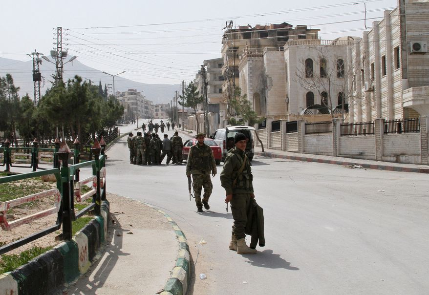 Syrian government forces walk after being deployed in Yabroud town, Syria, Sunday, March 16, 2014. Syrian troops backed by Hezbollah fighters seized a key rebel supply town on the Lebanese border on Sunday, driving them from the area and scoring a major blow against them in the three-year-old-conflict. The fall of Yabroud immediately emboldened government forces to attack nearby rebel-held towns, pressing forward in what has been nearly a yearlong advance against rebels fighting to overthrow President Bashar Assad. (AP Photo)