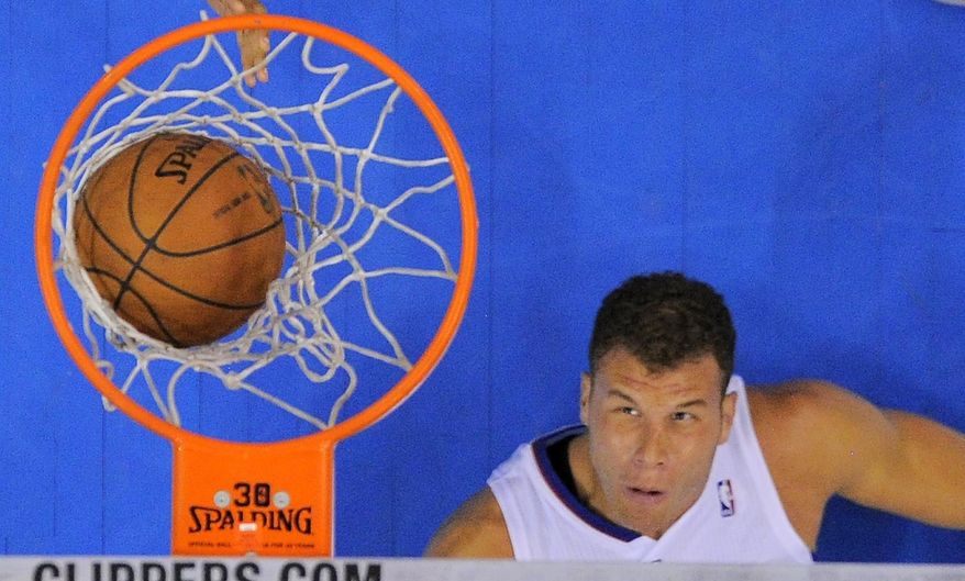 Los Angeles Clippers forward Blake Griffin watches his shot go in while laying on the floor during the first half of an NBA basketball game against the Milwaukee Bucks, Monday, March 24, 2014, in Los Angeles. (AP Photo/Mark J. Terrill)