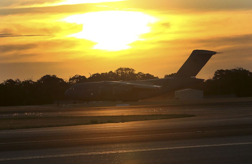 Royal Australia Air Force C-17 lands at RAAF Base Pearce to deliver a Sea Hawk helicopter to help with the search for the missing Malaysia Airlines Flight MH370, in Perth, Australia, Friday, March 28, 2014. Australian officials moved the search area for the lost Malaysian jetliner 1,100 kilometers (680 miles) to the northeast Friday, following a new analysis of radar data, and a plane quickly found objects that a ship set out to investigate. (AP Photo/Rob Griffith)