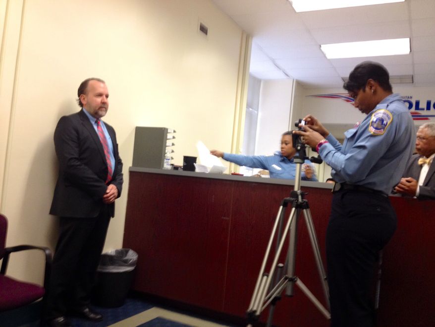Businessman Mark Witaschek submits to a mugshot for the D.C. Gun Offenders Registry at Metropolitan Police Department. March 28, 2013.