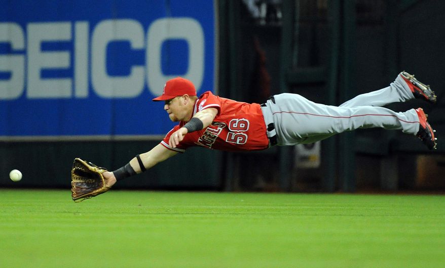 Los Angeles Angels' Kole Calhoun dives but misses catching a line drive hit by Houston Astros' Jose Altuve in the fourth inning of a baseball game on Friday, April 4, 2014, at Minute Maid Park in Houston. (AP Photo/Eric Christian Smith)