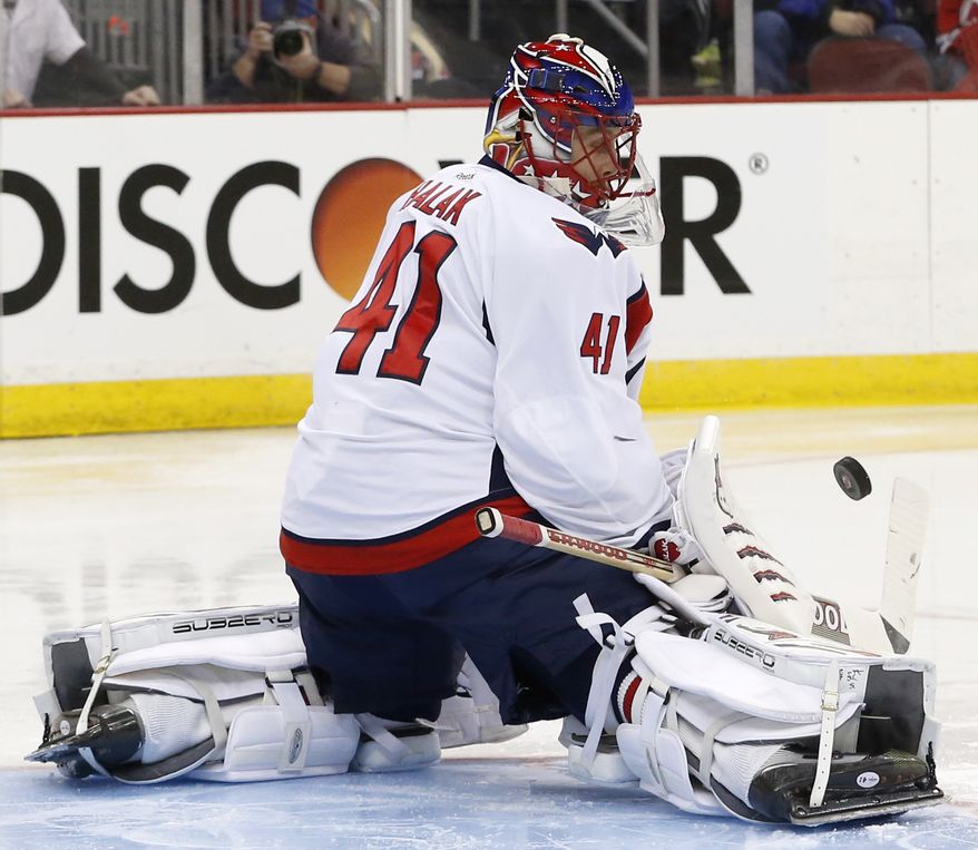 Washington Capitals goalie Jaroslav Halak, of Slovakia, makes a save against the New Jersey Devils during the second period of an NHL hockey game, Friday, April 4, 2014, in Newark, N.J. (AP Photo/Julio Cortez)
