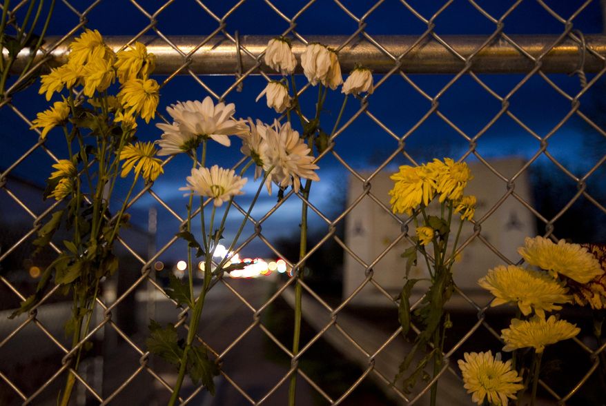 Flowers hang at the East Gate of the army base at Fort Hood, Texas, on Friday, April 4, 2014, in honor of the victims of Wednesday's shooting. The Fort Hood soldier who gunned down three other military men before killing himself had an argument with colleagues in his unit before opening fire, and investigators believe his mental condition was not the "direct precipitating factor" in the shooting, authorities said Friday. (AP Photo/Austin American-Statesman, Jay Janner)