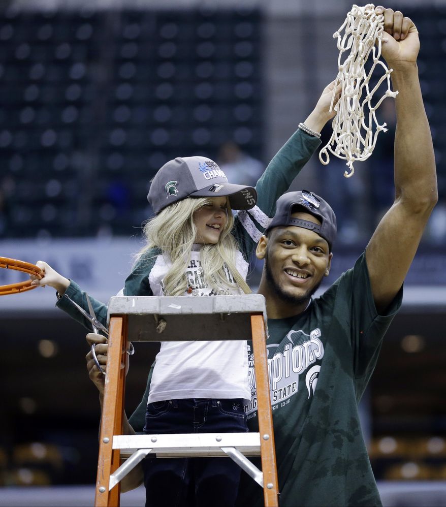 ** FILE ** In this March 16, 2014, file photo, Michigan State forward Adreian Payne, right, hoists the net with Lacey Holsworth, who is battling cancer, after Michigan State defeated Michigan 69-55 in an NCAA college basketball game in the championship of the Big Ten Conference tournament in Indianapolis. The father of 8-year-old Lacey Holsworth, who befriended Michigan State basketball star Adreian Payne, says his daughter has died. (AP Photo/Michael Conroy, File)