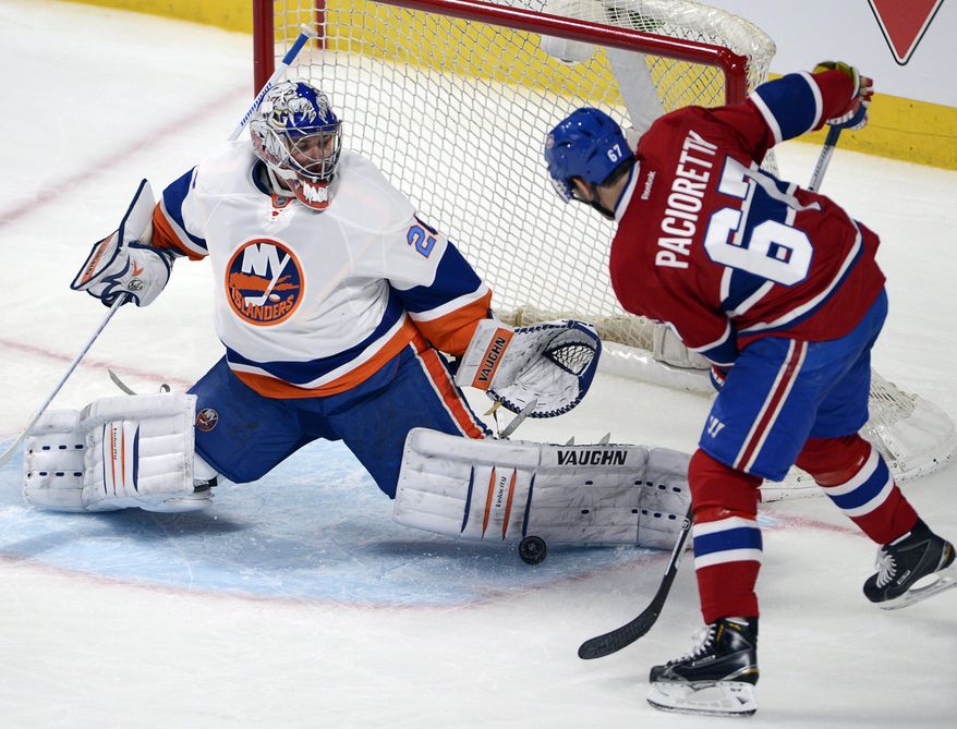New York Islanders goalie Evgeni Nabokov (20) stops Montreal Canadiens left wing Max Pacioretty during the second period of an NHL hockey game Thursday, April 10, 2014, in Montreal. (AP Photo/The Canadian Press, Ryan Remiorz)