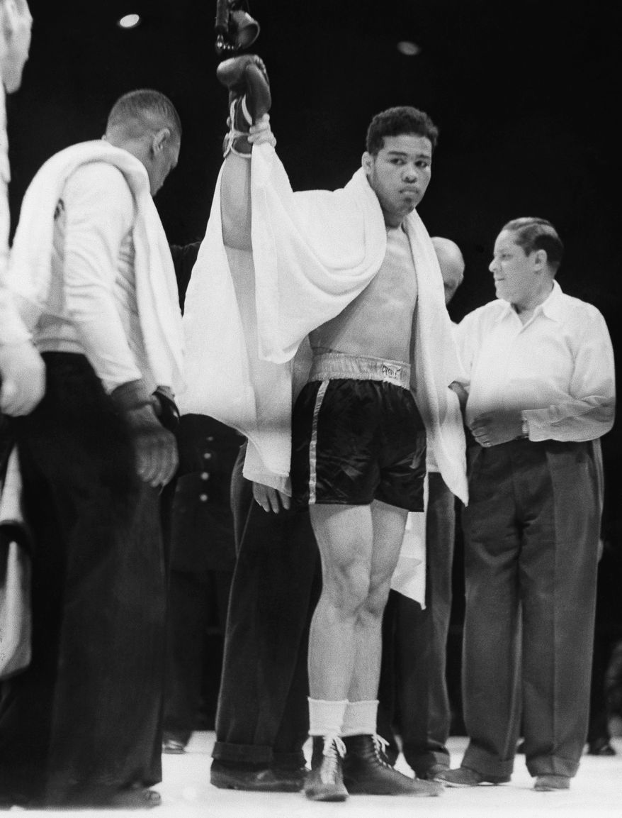 Joe Louis raises his right arm as he reaches the peak of his career after he knocked out Max Schmeling in the first round at Yankee Stadium June 22, 1938 in New York. This was the second fight between the two heavyweights, a rematch that created world wide interest. Schmeling was sent to the canvas several times with referee Arthur Donovan making Louis the winner, by a knockout, two minutes and four seconds into the first round. (AP Photo)