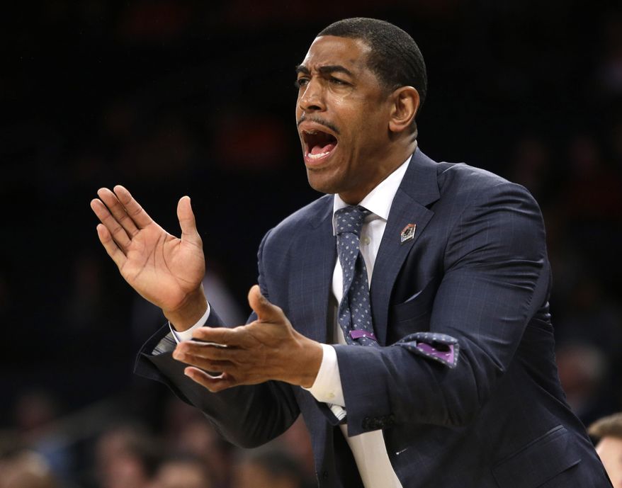FILE - In this March 28, 2014 file photo, Connecticut coach Kevin Ollie shouts instructions during the first half in a regional semifinal against Iowa State in the NCAA men's college basketball tournament in New York. Ollie is listening to job offers, but isn't looking to leave Connecticut. The 41-year-old coach, who spent 13 years as an NBA journeyman before returning to his alma mater, has been linked to several NBA job openings. (AP Photo/Frank Franklin II, File)