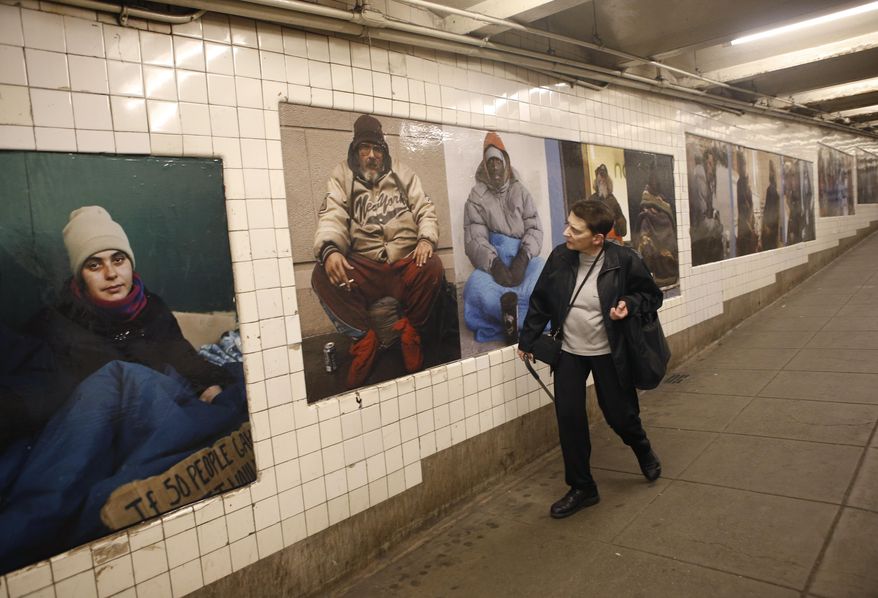 A woman cranes her neck as she passes by some of photographer Andres Serrano's portraits of homeless New Yorkers currently on display at the West 4th Street subway station in New York, Wednesday, May 21, 2014. Best known for his controversial image of a crucifix dunked in his own urine, Serrano chose to show his portraits in some of the very places his unassuming subjects often populate_a subway station, a park and a church. (AP Photo/Kathy Willens)