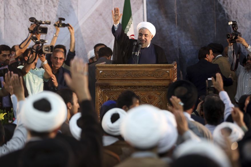 Iranian President Hassan Rouhani waves as he arrives to deliver a speech during a ceremony marking the 25th death anniversary of Ayatollah Khomeini, the founder of the Islamic Republic, at his shrine just outside Tehran, Iran, Tuesday, June 3, 2014. Iran's moderate president said Tuesday that his administration will defend the Islamic Republic's nuclear rights and work to end international sanctions that have devastated its economy. (AP Photo/Vahid Salemi)
