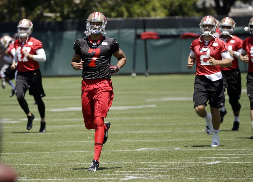 San Francisco 49ers quarterback Colin Kaepernick (7) runs with teammates during an NFL football organized team activity, Tuesday, June 3, 2014, in Santa Clara, Calif. (AP Photo/Marcio Jose Sanchez)