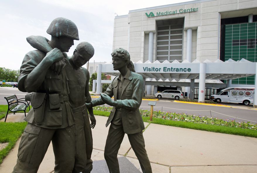 Three statues portraying a wounded soldier being helped, stand on the grounds of the Minneapolis VA Hospital, Monday, June 9, 2014. (AP Photo/Jim Mone)