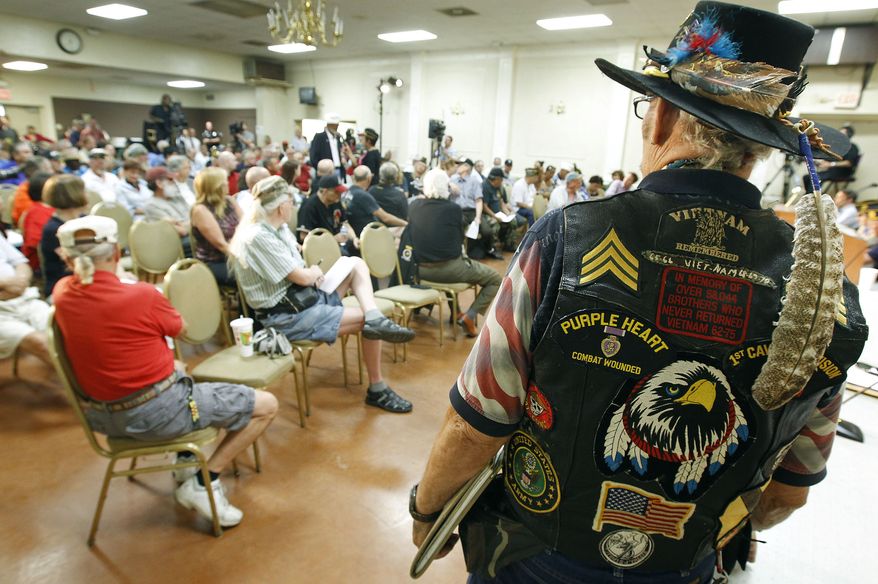 ** FILE ** Vietnam veteran Ron Silver Eagle D'Andre, right, listens during a town hall meeting at American Legion Post 1 on Monday, June 9, 2014, in Phoenix concerning health-care issues at the Phoenix VA facilities. (AP Photo/Ralph Freso)