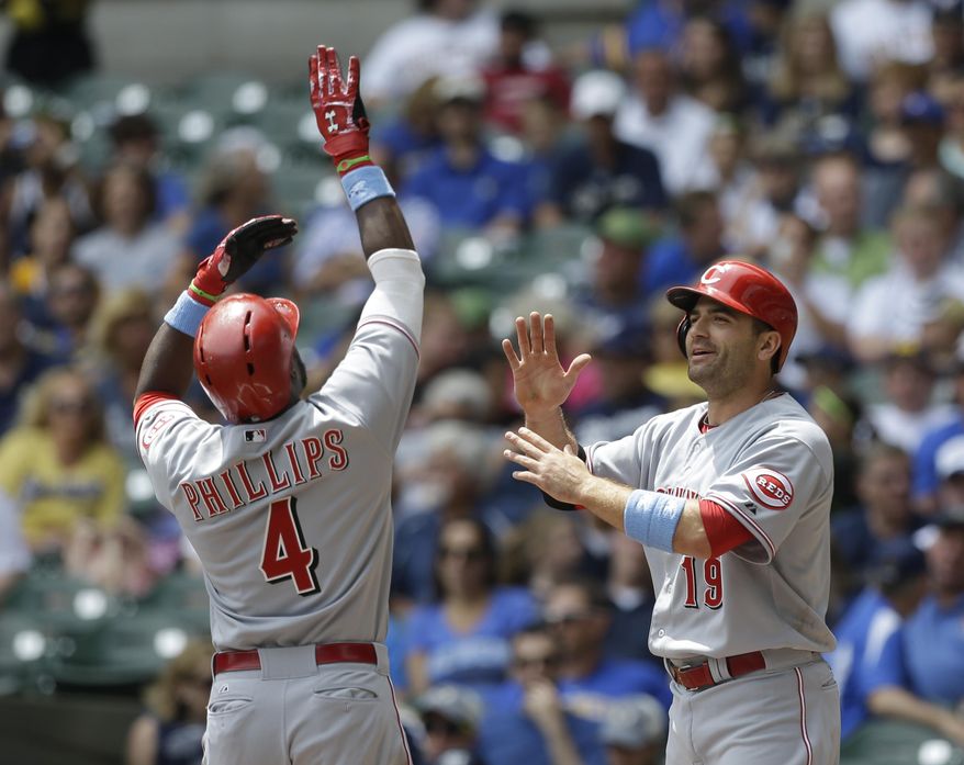 Cincinnati Reds' Brandon Phillips (4) gets a high-five from teammate Joey Votto after hitting a two-run home run during the first inning of a baseball game against the Milwaukee Brewers, Sunday, June 15, 2014, in Milwaukee. (AP Photo/Jeffrey Phelps)
