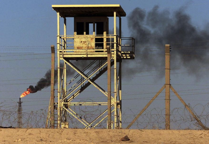 File - In this Monday, Oct. 6, 2003 file photo, an abandoned watchtower and lines of barbed wire are seen surrounding Iraq's largest oil refinery as smoke rises from a petroleum gas flare, in the city of Beiji, north of Baghdad. On Wednesday, June 18, 2014, a top Iraqi security official said Islamic militants of the al-Qaida-inspired Islamic State of Iraq and the Levant laid siege to Iraq's largest oil refinery late Tuesday night, threatening a facility key to the country's domestic supplies as part of their ongoing lightning offensive across the country. The Beiji refinery accounts for a little more than a quarter of the country's entire refining capacity and any lengthy outage at Beiji risks long lines at the gas pump and electricity shortages, adding to the chaos already facing Iraq. (AP Photo/Ivan Sekretarev, File)