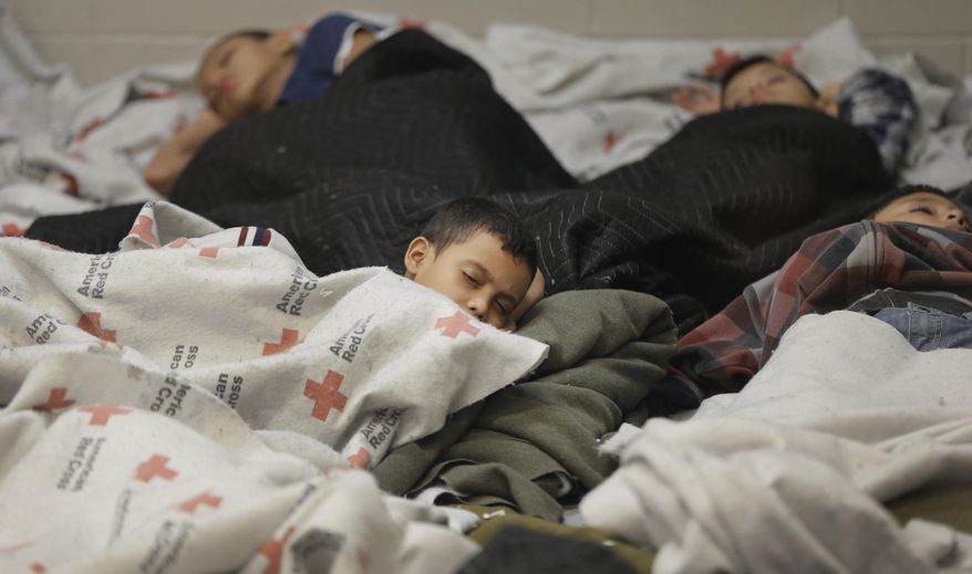 ** FILE ** This June 18, 2014, file photo shows children detainees sleeping in a holding cell at a U.S. Customs and Border Protection processing facility in Brownsville, Texas. (AP Photo/Eric Gay, Pool)