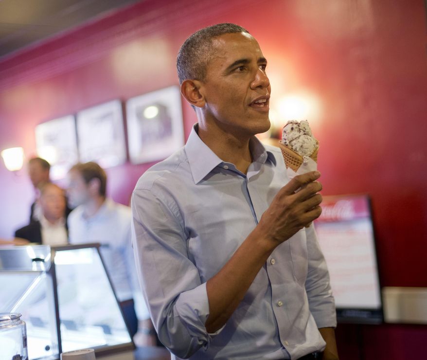 President Barack Obama holds his ice cream cone during a visit to Grand Ole Creamery in St. Paul, Minn., Thursday, June 26, 2014. (AP Photo/Pablo Martinez Monsivais)