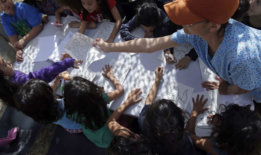 ** FILE ** This June 18, 2014, file photo shows children detainees coloring and drawing at a U.S. Customs and Border Protection (CPB) processing facility in Brownsville,Texas. (AP Photo/Eric Gay, Pool)
