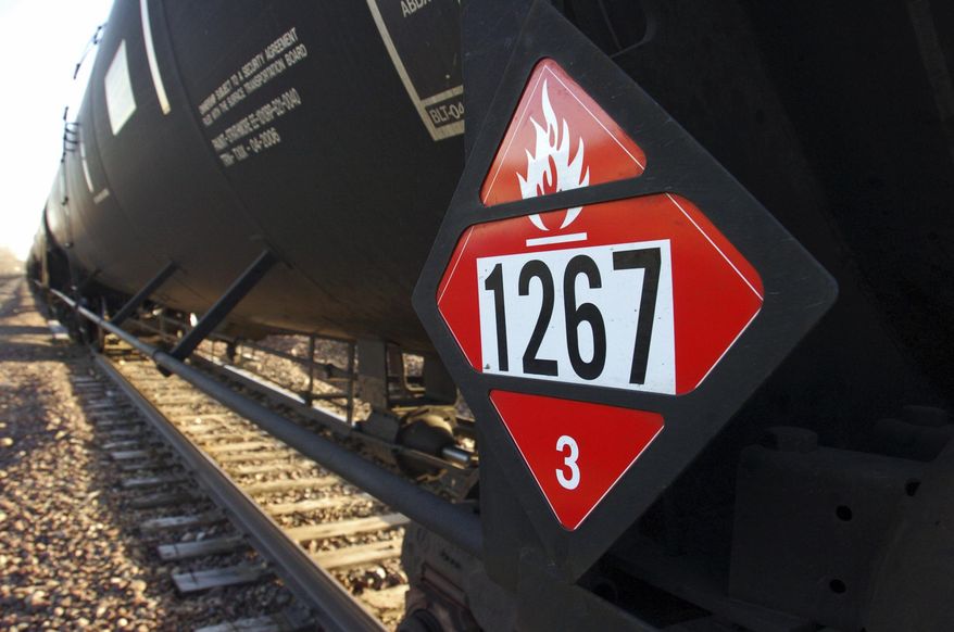 FILE - This Nov. 6, 2013 file photo shows a warning placard on a tank car carrying crude oil near a loading terminal in Trenton, N.D. Thousands of older rail tank cars that carry crude oil would be phased out within two years under regulations proposed in response to a series of fiery train crashes over the past year. Transportation Secretary Anthony Foxx said the government's testing of crude oil from the Bakken region of North Dakota and Montana shows the oil is on the high end of a range of volatility compared with other crude oils, meaning it's more likely to ignite if spilled. (AP Photo/Matthew Brown, File)