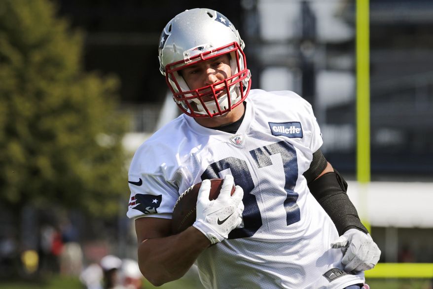 New England Patriots tight end Rob Gronkowski runs with the ball after catching a pass during an NFL football training camp in Foxborough, Mass., Friday, July 25, 2014. (AP Photo)