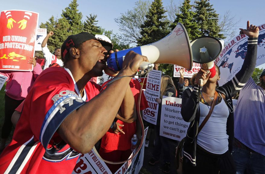 ** FILE ** In this May 22, 2014, file photo, protesters gather outside of the McDonald's Corp. headquarters in Oak Brook, Ill., the annual shareholders meeting demonstrating for higher wages and the right to unionize. On Friday, July 25, 2014, in Chicago, organizers are holding what they're calling the first national convention of fast-food workers. (AP Photo/M. Spencer Green, File)
