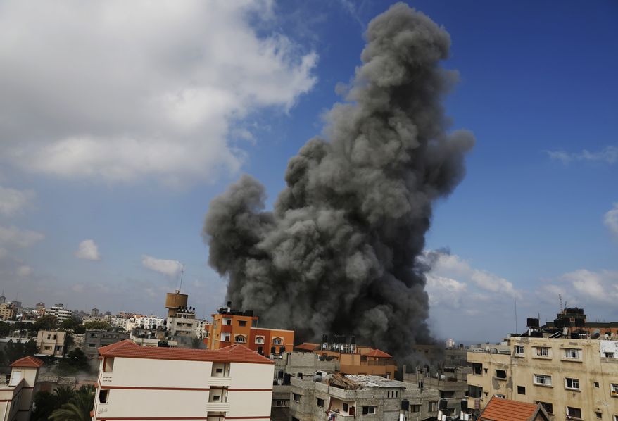 Smoke rises after an Israeli strike hit the offices of the Hamas movement's Al-Aqsa satellite TV station, in Gaza City, northern Gaza Strip, Thursday, July 31, 2014. Israel said Thursday it has called up another 16,000 reservists, allowing it to potentially widen its Gaza operation against the territory's Hamas rulers in a war that has killed more than 1,300 Palestinians and more than 50 Israelis. (AP Photo/Hatem Moussa)