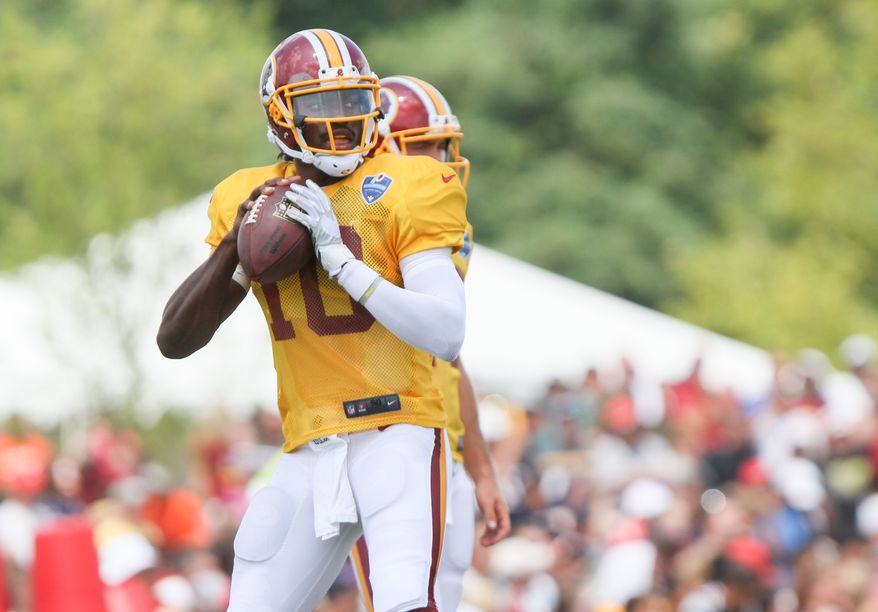 Washington Redskins QB Robert Griffin III works out before an NFL Football training camp scrimmage of New England Patriots and Washington Redskins in Richmond, Va., Tuesday, Aug. 5, 2014. (AP Photo/Skip Rowland)
