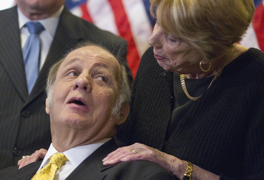 ** FILE ** This March 30, 2011, file photo shows former White House press secretary James Brady, left, who was left paralyzed in the Reagan assassination attempt, looking at his wife Sarah Brady, during a news conference on Capitol Hill in Washington marking the 30th anniversary of the shooting. This week's death of former White House press secretary James Brady, who survived a gunshot wound to the head in a 1981 assassination attempt on President Ronald Reagan, has been ruled a homicide, District of Columbia police said Friday, Aug. 8, 2014. (AP Photo/Evan Vucci, File)
