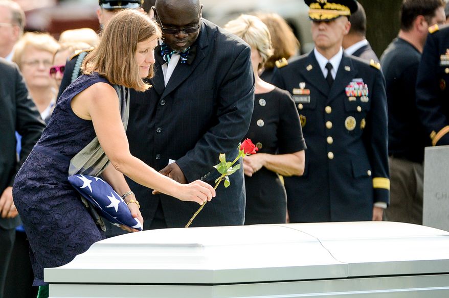 Dr. Susan Myers, the wife of Army Maj. Gen. Harold J. Greene puts a rose on his coffin during his funeral service at Section 60 at Arlington National Cemetery, Arlington, Va., Thursday, August 14, 2014. Greene was killed in Afghanistan while at the national military academy in Kabul. He was the highest-ranking U.S. Army officer killed in combat since the Vietnam War. (Andrew Harnik/The Washington Times)