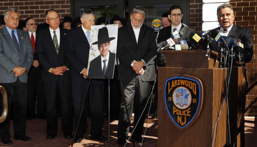 U.S. Rep. Chris Smith, right, R-NJ, addresses a gathering as he stands near a photograph of Aaron Sofer, center, 23, Tuesday, Aug. 26, 2014, in Lakewood, N.J. Israeli police said Tuesday they are searching for the young New Jersey religious student who went missing in Israel during a hike in a forest outside Jerusalem last week. Sofer of Lakewood, New Jersey, has been missing since Friday when he went on a hike with a friend in the Jerusalem Forest, said police spokesman Micky Rosenfeld. (AP Photo/Mel Evans)