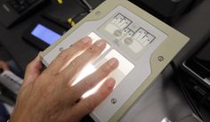 Airline passenger Tom Reichert is digitally fingerprinted in the new Transportation Security Administration application site at the Detroit Metropolitan Airport in Romulus, Mich., Thursday, Feb. 19, 2015. (AP Photo/Carlos Osorio)