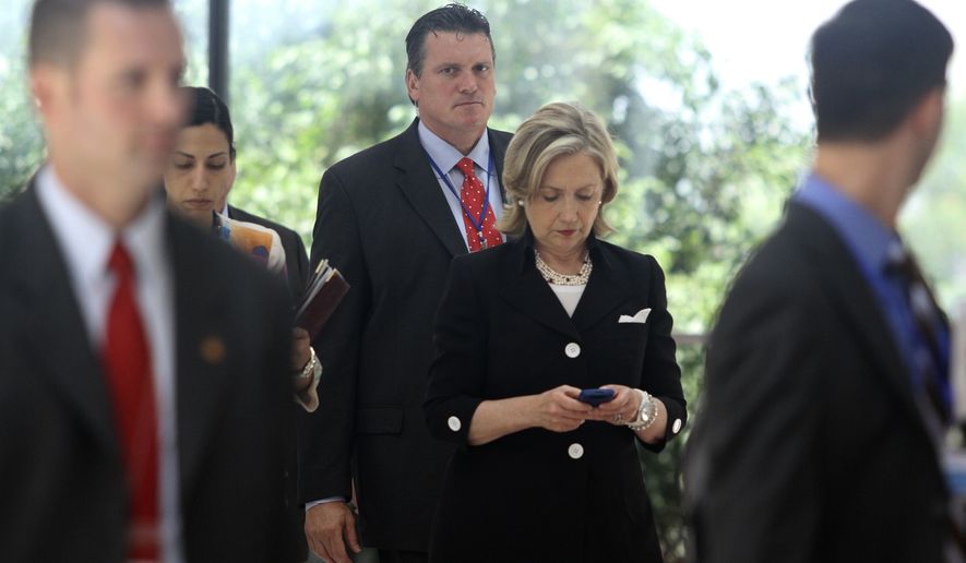 Secretary of State Hillary Rodham Clinton checks her phone after attending a U.S.-Russia meeting in Hanoi, Vietnam on July 23, 2010. The revelation that Mrs. Clinton used an off-the-books email account during her time as secretary of state has raised fresh questions about her credibility heading into 2016. (Associated Press)