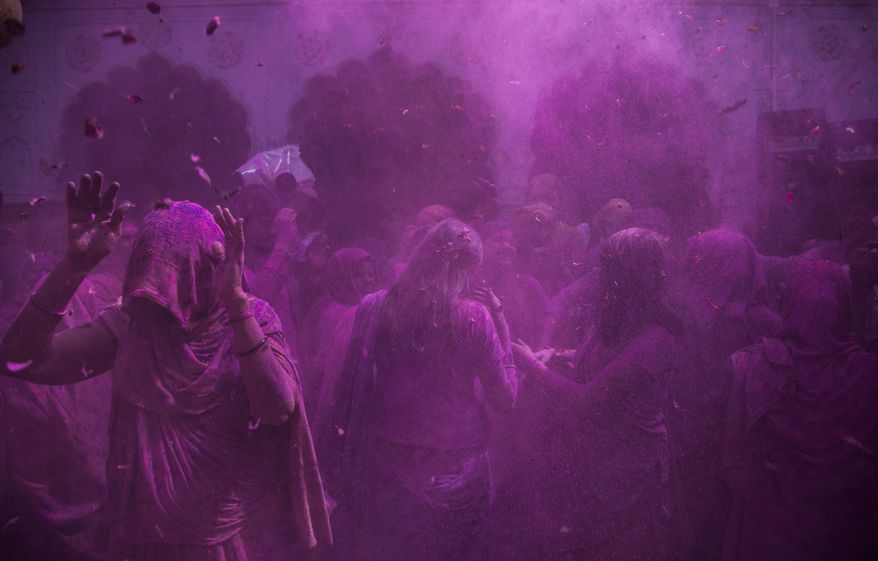 Indian Hindu widows play with colored powder as part of Holi celebrations at the Pagal Baba Ashram in Vrindavan, India, Tuesday, March 3, 2015. The widows, many of whom at times have lived desperate lives in the streets of the temple town, celebrated the Hindu festival of colors at the ashram. (AP Photo/Tsering Topgyal)