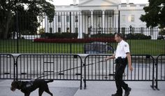 A member of the Secret Service Uniformed Division with a K-9 walks along the perimeter fence along Pennsylvania Avenue outside the White House in Washington, Sept. 22, 2014. (Associated Press) ** FILE **