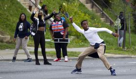 Demonstrators throw rocks at the police after the funeral of Freddie Gray on Monday, April 27, 2015, at New Shiloh Baptist Church in Baltimore. Gray died from spinal injuries about a week after he was arrested and transported in a Baltimore Police Department van. (AP Photo/Jose Luis Magana)