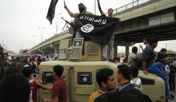 Al Qaeda fighters wave flags as they patrol the streets in a commandeered Iraqi military vehicle in Fallujah, Iraq, March 20, 2014. (Associated Press) ** FILE **