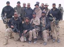A photo of Army Lt. Col. Jason Amerine and his team with Afghan freedom fighters in 2001. Col. Amerine is in the first row, second from the right. The turbaned man standing in the second row is Hamid Karzai, who later became Afghanistan's first democratically elected president.