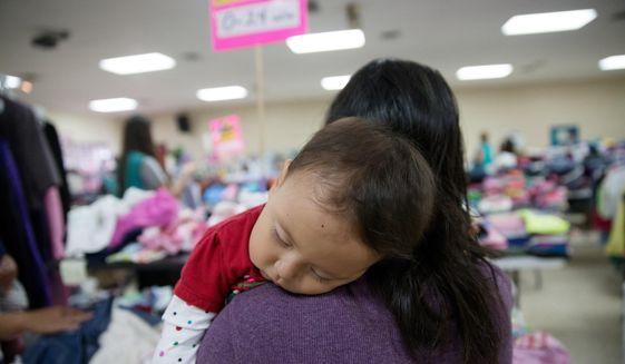 In this April 30, 2015 photo, Gladys Pina, 30, from Honduras holds her 8-month old baby girl at a respite center run by Catholic Charities in McAllen, Texas. She was among nearly two-dozen immigrant mothers who arrived at the center after being released by Border Patrol. Rather than getting locked up in a family detention facility, some families are released by Border Patrol with notices to appear in immigration court. (AP Photo/Seth Robbins)