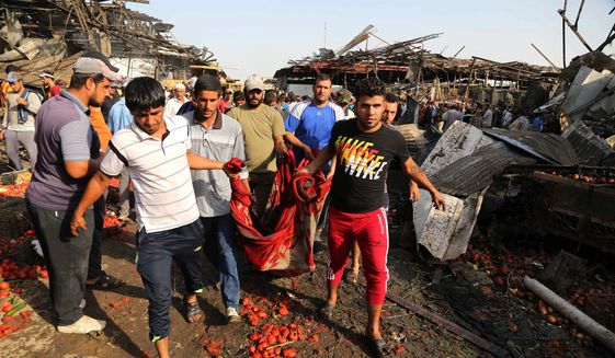 People evacuate the body of a victim killed from a bombing in Jameela market in the Iraqi capital&#39;s crowded Sadr City neighborhood Baghdad, Iraq, Thursday, Aug. 13, 2015. A massive truck bomb ripped through a popular Baghdad food market in a predominantly Shiite neighborhood in the early morning hours on Thursday, killing at least 62 people, police officials said. (AP Photo/Karim Kadim)