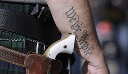 Scott Smith, a supporter of open carry gun laws, wears a pistol as he prepares for a rally at the Capitol on Jan. 26, 2015, in Austin, Texas. (Associated Press)