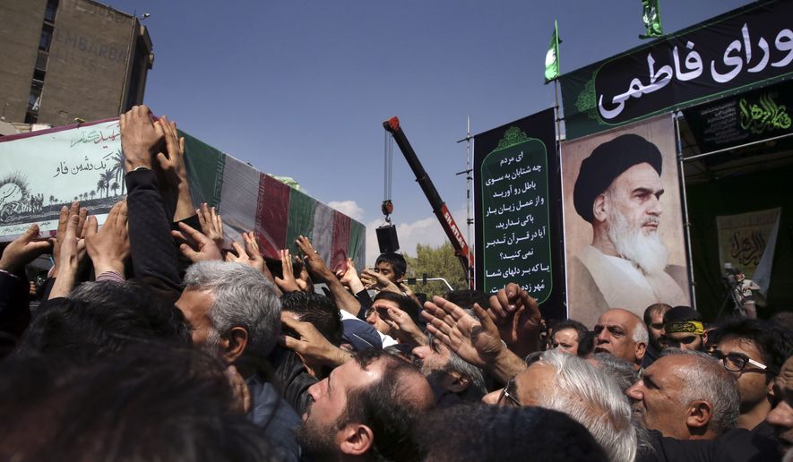 In front of a portrait of the late Iranian revolutionary founder Ayatollah Khomeini, mourners carry a flag draped coffin of an unknown Iranian soldier who was killed during the 1980-88 Iran-Iraq war, whose remains were recently recovered, during a ceremony commemorating the death anniversary of Fatima, the daughter of Islam&#39;s Prophet Muhammad, in Tehran, Iran, Sunday, March 13, 2016. (AP Photo/Vahid Salemi)