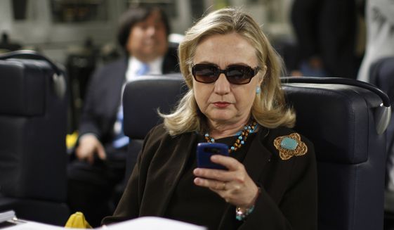 In this Oct. 18, 2011, file photo, then-Secretary of State Hillary Rodham Clinton checks her Blackberry from a desk inside a C-17 military plane upon her departure from Malta, in the Mediterranean Sea, bound for Tripoli, Libya. Newly released emails show a 2009 request to issue a secure government smartphone to then-Secretary of State Hillary Clinton was denied by the National Security Agency. (AP Photo/Kevin Lamarque, Pool, File)
