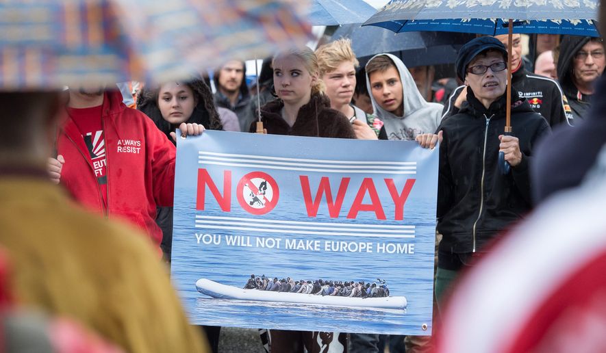 The National Democratic Party organized a demonstration against Germany&#39;s asylum law after the U.N. refugee agency reported that more than 158,450 people, including over 50,000 in July alone, had arrived on the shores of Greece last year in hopes of migrating within Europe. (Associated Press)