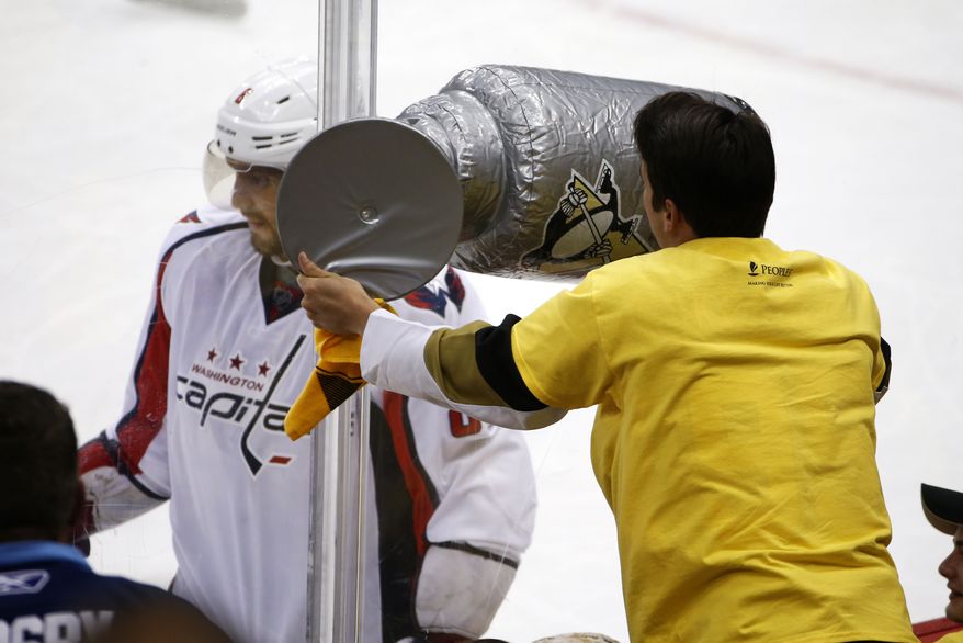 A Pittsburgh Penguins fan waves an inflatable Stanley Cup at Washington Capitals' Alex Ovechkin, left, during the third period of Game 4 in an NHL hockey Stanley Cup Eastern Conference semifinals in Pittsburgh, Wednesday, May 4, 2016. (AP Photo/Gene J. Puskar)