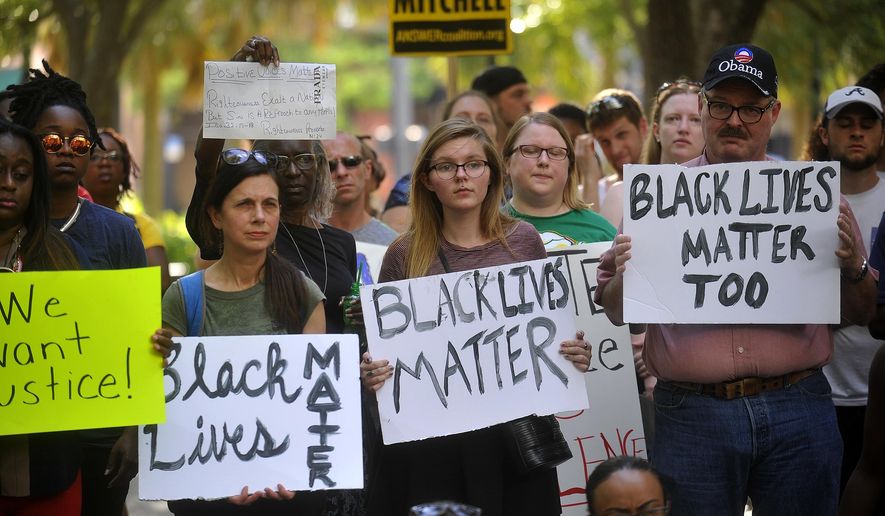 Protesters hold signs during a Black Lives Matter movement protest at Lykes Gaslight Park in downtown Tampa, Fla., Monday, July 11, 2016. (Octavio Jones/Tampa Bay Times via AP)